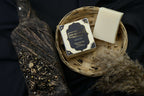 AMI NATURAL BLACK OUDH SOAP pack with black and gold decorative box and plain off-white soap bar in woven basket