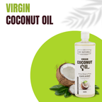 AMI NATURAL Virgin Coconut Oil 500ml transparent plastic bottle with label, surrounded by a halved coconut and green leaves on a white background with green accent