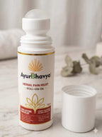 Pain Relief Roll On Oil in white cylindrical plastic bottle with gold and brown label featuring herbal motifs and an open cap